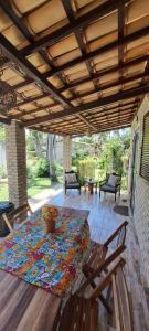 a patio with a table and chairs on a deck at Fiquei In Pipa - Chalé 21 in Pipa