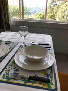a table with a plate and a wine glass on it at The yellow house in Lower Barrington