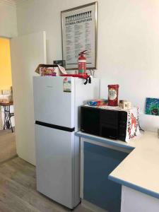 a kitchen with a white refrigerator and a microwave at The yellow house in Lower Barrington +5 photos