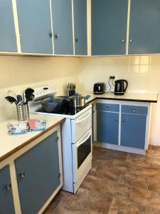 a kitchen with blue cabinets and a white stove top oven at The yellow house in Lower Barrington