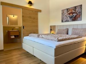 une chambre avec un lit avec un tableau sur le mur dans l'établissement Grebenzen Lodge Starnberg 60A, à Sankt Lambrecht