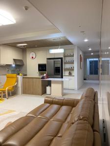 a living room with a couch and a kitchen at Sky lounge with Han River view, Ilsan Lake Park, KINTEX, Goyang Sports Complex, Gimpo Airport- Landmark Stay in Ilsan exclusively for foreigners in Goyang