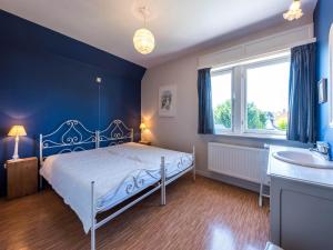 a blue bedroom with a bed and a sink at LAuthentique in Sint-Idesbald