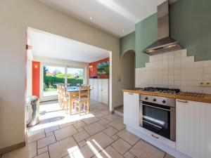 a kitchen with a stove and a dining room at LAuthentique in Sint-Idesbald