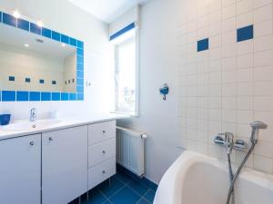 a bathroom with a tub and a sink and a bath tub at LAuthentique in Sint-Idesbald