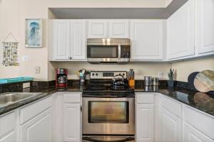 een keuken met witte kasten en een kookplaat oven bij Ocean Front Condo 29th Floor - Must be 25 to Book in Panama City Beach +33 foto's