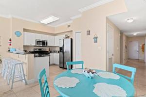 een keuken en eetkamer met een blauwe tafel en stoelen bij Ocean Front Condo 29th Floor - Must be 25 to Book in Panama City Beach