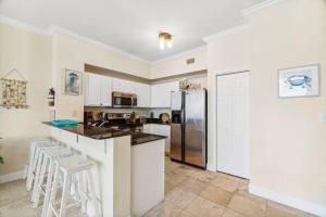 een keuken met witte kasten en een roestvrijstalen koelkast bij Ocean Front Condo 29th Floor - Must be 25 to Book in Panama City Beach