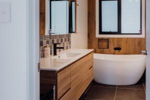 a bathroom with a tub and a sink and two windows at Doric Dreams - Short Stroll to St Helens in St Helens +20 photos