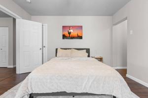 a white bedroom with a bed and a painting on the wall at Charming 1-Bedroom Retreat in Fort Worth in Fort Worth