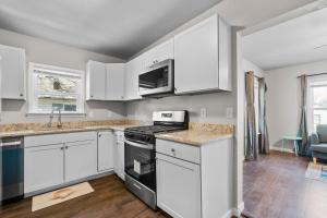 a kitchen with white cabinets and a stove top oven at Charming 1-Bedroom Retreat in Fort Worth in Fort Worth