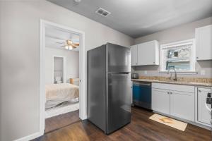 a kitchen with a stainless steel refrigerator and a bed at Charming 1-Bedroom Retreat in Fort Worth in Fort Worth +9 photos