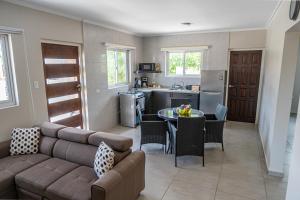 Una sala de estar con un sofá y una mesa y una cocina. en N-Joy Aruba, en Cunucu Abao