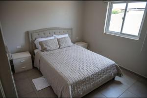 Un dormitorio con una cama grande con ventana. en N-Joy Aruba, en Cunucu Abao