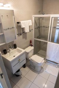 Un baño con lavabo, inodoro y ducha. en N-Joy Aruba, en Cunucu Abao