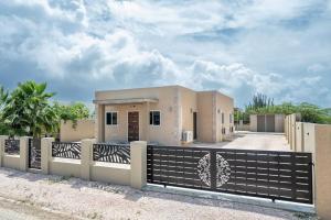 una casa con una valla delante en N-Joy Aruba, en Cunucu Abao