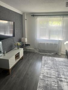 a living room with a couch and a window at The Cosy Haven - 2 Bedroom house in Manchester