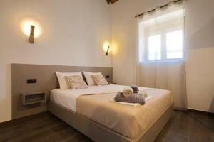 a bedroom with a large bed with a window at 4 Lemons Luxury Studios in Ammouliani
