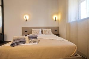 a bedroom with a large bed with towels on it at 4 Lemons Luxury Studios in Ammouliani