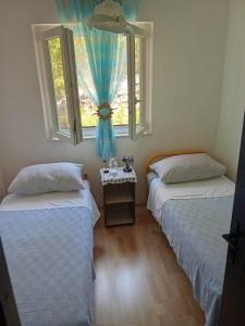 twee bedden in een kamer met twee ramen bij Seaside secluded apartments Cove Virak, Hvar - 6969 in Gdinj