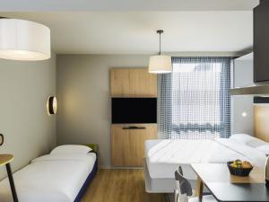 una habitación de hotel con dos camas y una mesa en Aparthotel Adagio access Palaiseau Saclay, en Palaiseau 56 fotos más