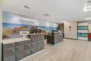Un vestíbulo de oficina con una pintura del océano. en Executive Residency by Best Western Corpus Christi, en Corpus Christi
