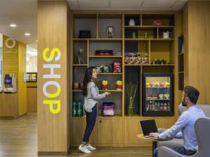 une femme debout devant une étagère dans un magasin dans l'établissement Aparthotel Adagio access Montpellier Centre, à Montpellier
