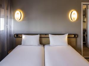 two beds sitting next to each other in a room at Aparthotel Adagio access Montpellier Centre in Montpellier +56 photos