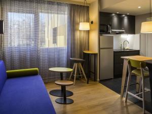 Aparthotel Adagio access Montpellier Centre في مونبلييه: غرفة معيشة مع أريكة ومطبخ +55 صورة