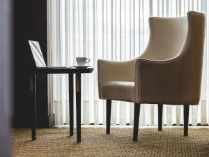 a chair sitting next to a table with a laptop at Mercure Bogota Calle 100 in Bogotá