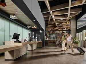 トレオンにあるIbis Torreonの荷物を持ってロビーを歩く男女