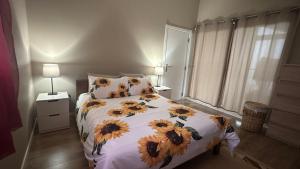 a bedroom with a bed with sunflowers on it at Casa Malee in Calheta