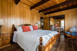 a bedroom with a large bed with red pillows at Hidden Pines Cabin - Nearby Snow & Play in Big Bear City Airport