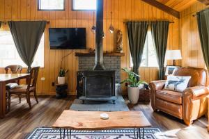a living room with a fireplace and a couch and a table at Hidden Pines Cabin - Nearby Snow & Play in Big Bear City Airport