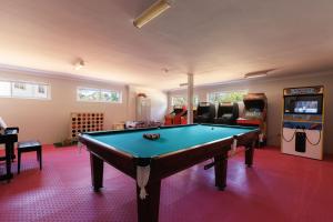 a room with a pool table and arcade games at Kyah in Blackheath