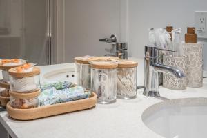 a bathroom counter with jars and a sink at Corner 2BR Old Port - Free Indoor Parking in Montreal