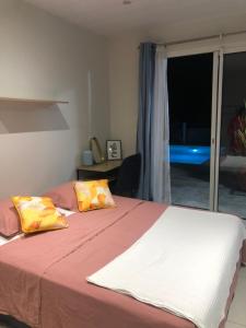 Un dormitorio con una cama con dos almohadas encima. en Chambre chez l'habitant, en Le Lamentin