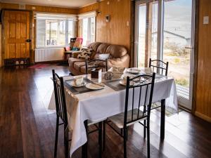 a dining room with a table and a couch at Cabañas Sierra Dorotea in Puerto Natales