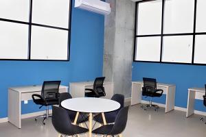 een conferentieruimte met stoelen en tafels en een blauwe muur bij Incredible 2Br Apt BBQ Arena Mty in Monterrey