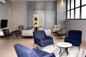 een wachtkamer met blauwe stoelen en tafels bij Incredible 2Br Apt BBQ Arena Mty in Monterrey