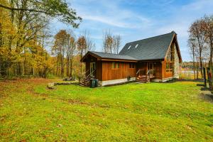 a small wooden cabin in the middle of a field at Golf, Fish and Ski Retreat with Game Room in Thompson in Thompson