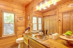 baño con lavabo y aseo en una cabaña de madera en Blue Ridge Cabin with Hot Tub, Fire Pit, and Game Room, en Cherry Log