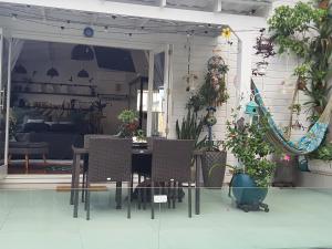 Un patio con mesa y sillas y plantas en macetas. en Lá Luciolla Loft Cabana, en São Marcos