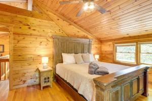 Un dormitorio con una cama en una cabaña de troncos en Blue Ridge Cabin with Hot Tub, Fire Pit, and Game Room, en Cherry Log