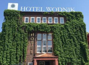 a building covered in ivy with a sign on it at Hotel Wodnik in Wrocław