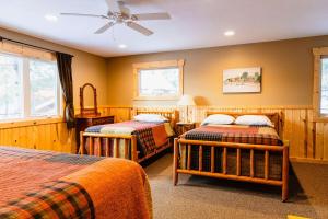Un dormitorio con dos camas y un ventilador de techo. en Oak at Pine Cone Lodge - 1 large bedroom, en Park Rapids