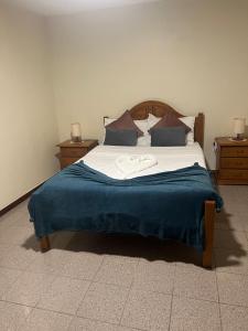 a bedroom with a large bed with a blue blanket at Retiro encantador em Machico - 5 min Praia e Centro A in Machico