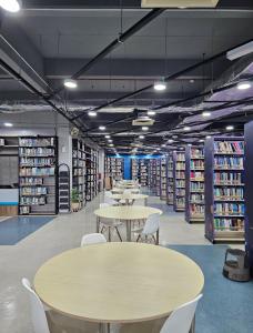 biblioteca con mesas, sillas y estanterías en ZZZ Sleep Mode Capsules- Larkin, en Johor Bahru