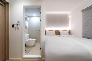 a bedroom with a white bed and a bathroom at Hi Stay Jongno in Seoul +53 photos