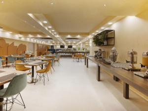 a restaurant with tables and chairs and a cafeteria at Mercure Istanbul Bakirkoy in Istanbul